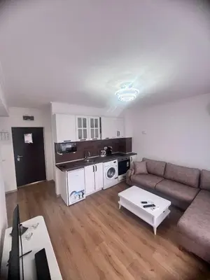 a living room with a couch and a table at Апартамент Дани in Obzor