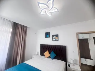a bedroom with a bed with blue and white at Апартамент Дани in Obzor