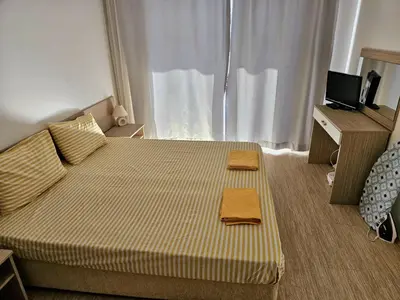 a bedroom with a bed with two towels on it at Двустаен апартамент Поморие in Pomorie