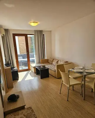 a living room with a couch and a table at Двустаен апартамент Поморие in Pomorie