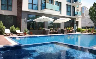 a swimming pool in front of a building with umbrellas at SUN GATE - Julia in Sunny Beach