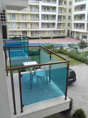 a balcony with a table and chairs and a building at SUN GATE - Julia in Sunny Beach