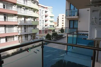 an empty balcony of a building with a bird on the railing at SUN GATE - Kamil in Sunny Beach