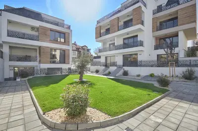 an apartment building with a lawn in front of it at MAESTRA Bamboo Beach Luxury Apartment - FREE Parking in Sozopol