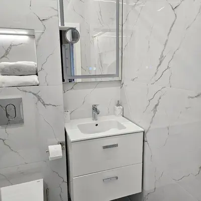 a white bathroom with a sink and a mirror at Арена Изгрев in Burgas City