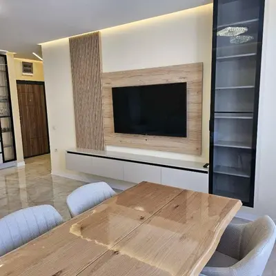 a dining room with a table and a flat screen tv at Арена Изгрев in Burgas City