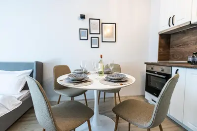 a small kitchen with a white table and chairs at Bella Mare Boutique apartment in Sunny Beach