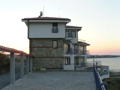 a building on the side of a body of water at Apartment Slantse in Sozopol