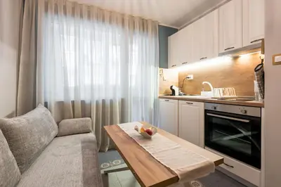 a small kitchen with a table and a couch at Vera Sweet Home in Varna City