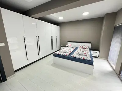 a bedroom with a bed and white cabinets at NJ Modigliani style in Varna City
