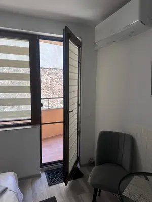 a bedroom with a window and a chair and a table at Star in Varna City