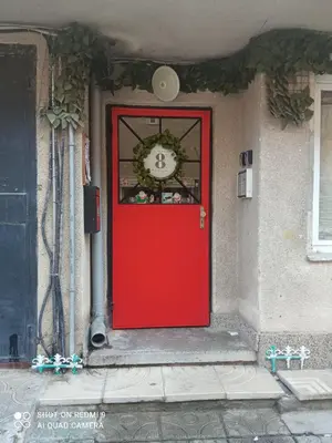 a red door with a clock on a building at International 2-star spacious 88 sq m apartment in Varna City