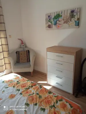 a bedroom with a dresser and a bed and a chair at International 2-star spacious 88 sq m apartment in Varna City
