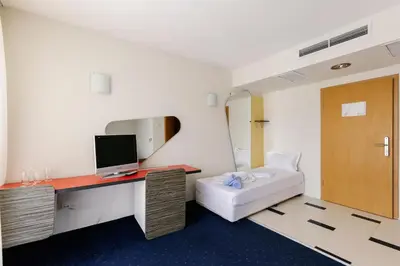 a room with a bed and a desk with a computer at APOLONIS hotel in Sozopol
