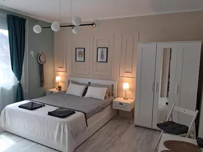 a bedroom with a large bed with two tables and two lamps at Varna Moreto in Varna City