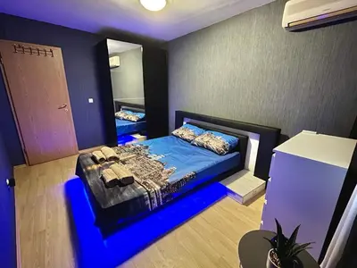 a bedroom with a bed with a blue lightedvisor at Black Sea Varna Centre in Varna City