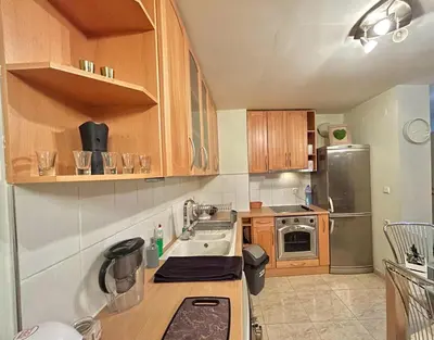 a kitchen with wooden cabinets and a stainless steel refrigerator at Black Sea Varna Centre in Varna City