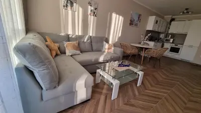 a living room with a couch and a table at АМИРА апартамент за гости - AMIRA guest apartment in Burgas City