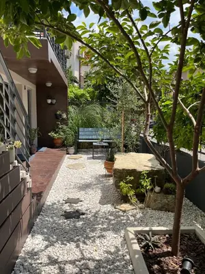 a small garden with a bench and a tree at Villa Mare Boutique Guesthouse by Flat Mаnаger in Pomorie