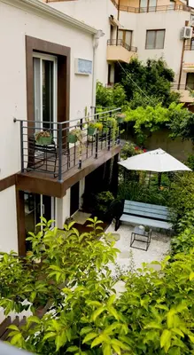 a balcony with a table and an umbrella and a bench at Villa Mare Boutique Guesthouse by Flat Mаnаger in Pomorie