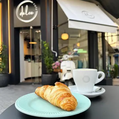a plate with a croissant and a cup of coffee at Apartment Musala N 01 in Varna City