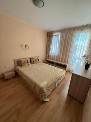 a bedroom with a large bed and two windows at Апартамент с одной спальней in Sunny Beach