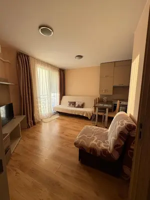 a small room with a bed and a table in it at Апартамент с одной спальней in Sunny Beach
