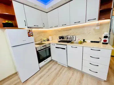 a kitchen with white cabinets and a white refrigerator at Glarus in Varna City