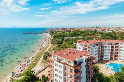 a view of a beach and buildings and the ocean at Riviera Fort Beach Apartment in Ravda