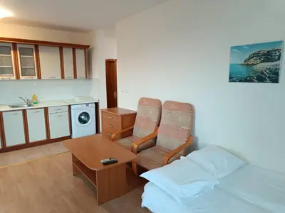 a bedroom with a bed and a chair and a table at Riviera Fort Beach Apartment in Ravda