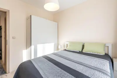 a bedroom with a bed with two green pillows at Varna Beach Apartment in Varna City