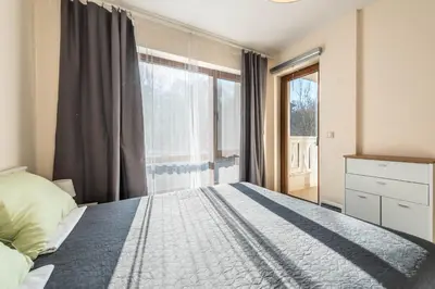 a bedroom with a bed and a large window at Varna Beach Apartment in Varna City