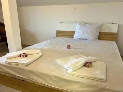 a bed with white towels and flowers on it at Villa Teos in Novo Panicharevo