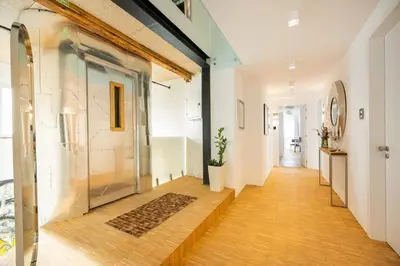a hallway with a large glass door and wooden floors at Apartment Musala N 04 in Varna City