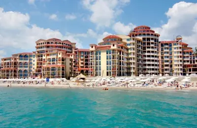 a hotel on the beach with people on the beach at Menada Atrium Beach Apartments in Elenite