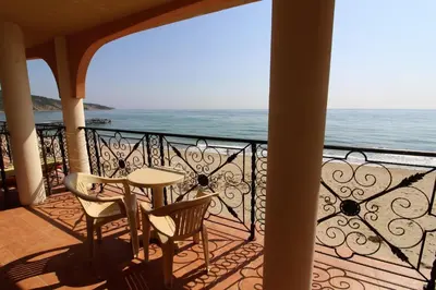 a balcony with a table and chairs and the ocean at Menada Atrium Beach Apartments in Elenite