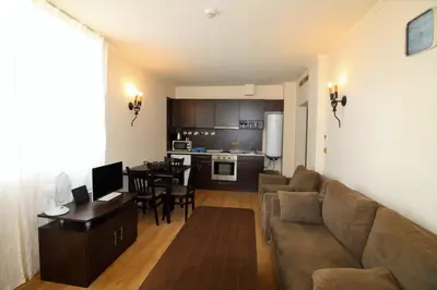 a living room with a couch and a dining room at Menada Atrium Beach Apartments in Elenite