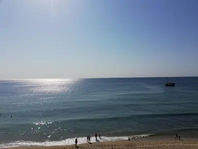 a group of people standing on a beach near the ocean at Menada Atrium Beach Apartments in Elenite