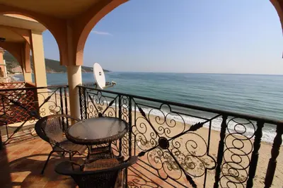 a balcony with a table and chairs and the ocean at Menada Atrium Beach Apartments in Elenite