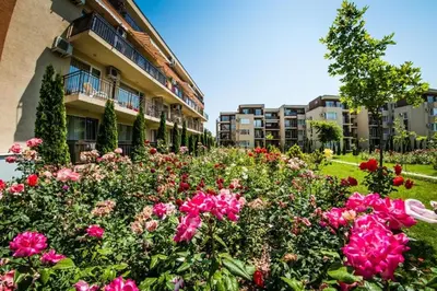 a garden of flowers in front of a building at Orchid Fort Noks Design in Sunny Beach