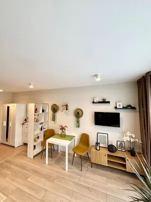 a living room with a table and chairs and a television at Orchid Fort Noks Design in Sunny Beach