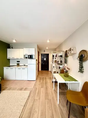 a kitchen with white cabinets and a table in a room at Orchid Fort Noks Design in Sunny Beach