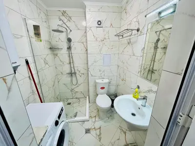 a bathroom with a toilet and a sink and a shower at Апартаменти Тутхон Поморие in Pomorie