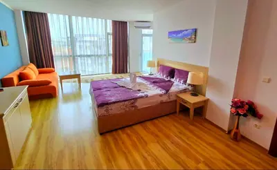 a bedroom with a bed and a couch in a room at Апартамент Del View гр Приморско in Primorsko