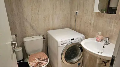 a small bathroom with a washing machine and a sink at Vladan apartments in Sozopol