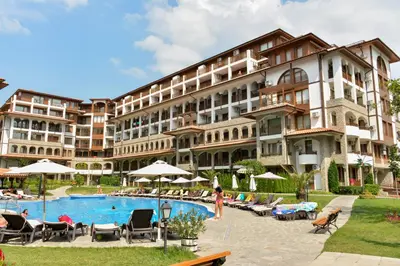 a hotel with a pool in front of a building at Private Apartments Olymp in Sveti Vlas