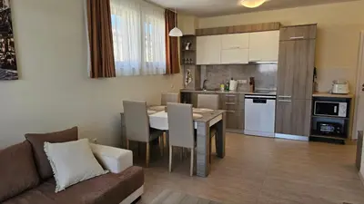 a living room and kitchen with a table and a couch at Vladan apartments in Sozopol
