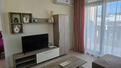 a living room with a flat screen tv on a wall at Vladan apartments in Sozopol