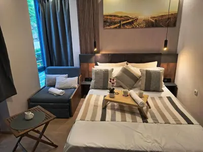 a bedroom with a bed and a chair and a table at Cozy private studios Excelsior Sunny Beach in Sunny Beach