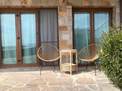two chairs and a table in front of a building at Panorama Bay-Serenity Haven in Burgas City